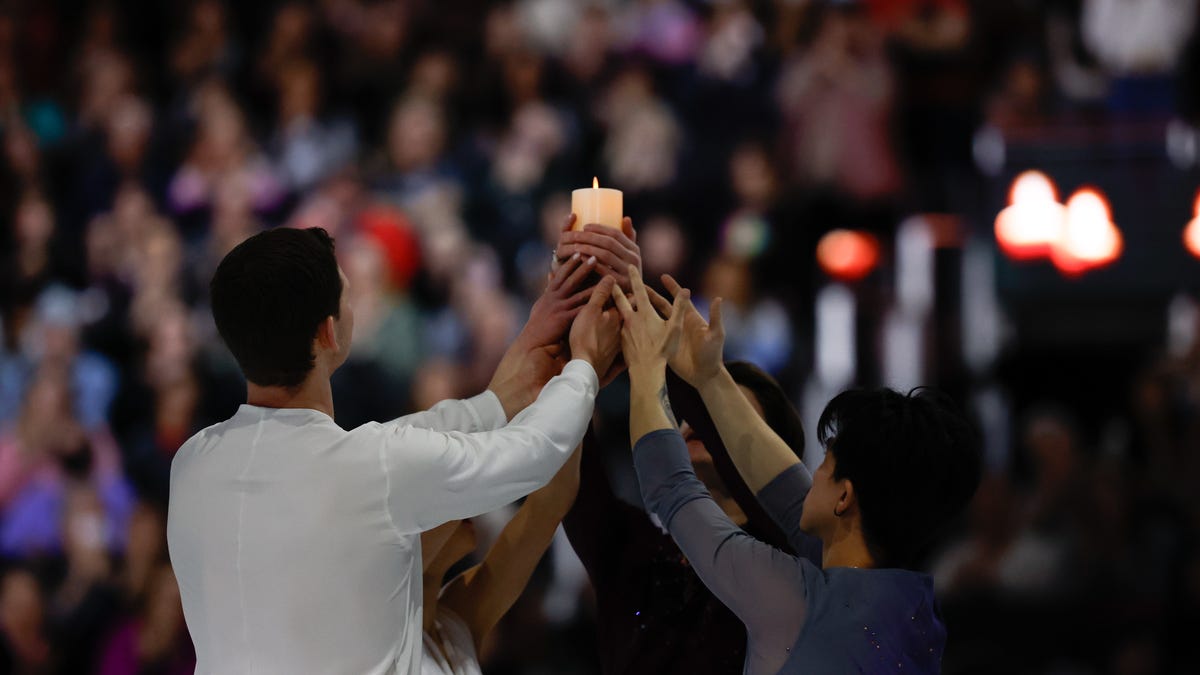 Mar 2, 2025; Washington D.C., USA; Maxim Naumov holds a candle with Alisa Efimova, Misha Mitrofanov, and Jimmy Ma performing a tribute to his parents, Vadim Naumov and Evgenia Shishkova, who died in the Potomac River mid-air collision during the Legacy on Ice benefit to support victims of the tragedy at Ronald Reagan Washington National Airport at Capital One Arena. Mandatory Credit: Geoff Burke-Imagn Images