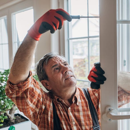 A worker installs windows.