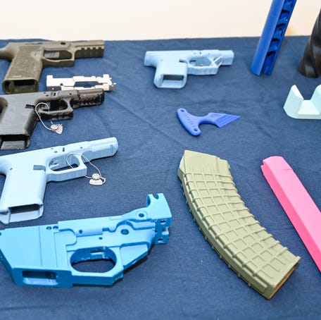 Illegal 3D guns that were seized by law enforcement in New York City are on display at a 2024 event by the Manhattan District Attorney's Office.