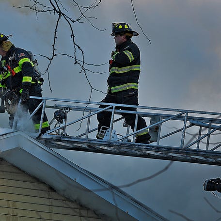 Firefighters cut vent holes in the roof to get at the flames in the attic of a single-family Craig Street home on Friday, Jan. 30, 2026. The fire progressed to two-alarms before firefighters got it under control.