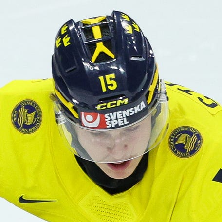Sweden forward Ivar Stenberg skates with the puck as Latvia forward Daniels Serkins defends during the second period in the quarterfinals of the 2026 IIHF World Junior Championship.