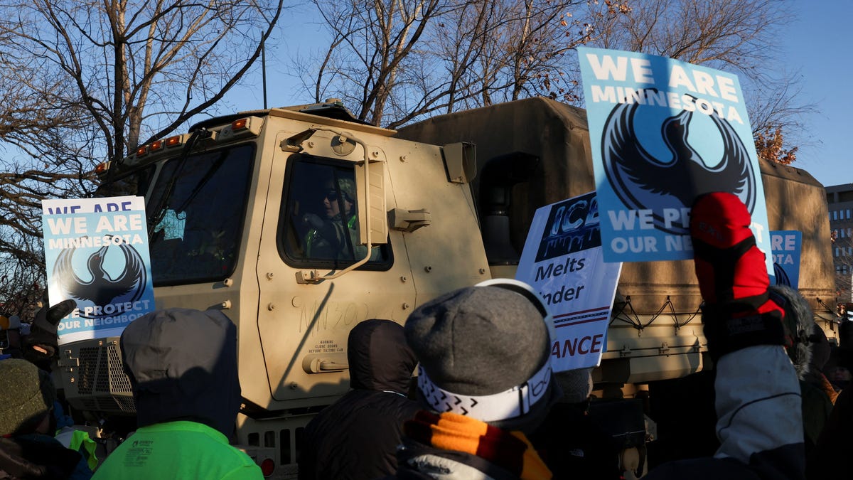 People walk by a National Guard vehicle as they protest outside the Bishop Henry Whipple Federal Building, after the fatal shootings of Renee Nicole Good and Alex Pretti by federal immigration agents, in Minneapolis, Minnesota on Jan. 30, 2026.