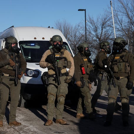 Law enforcement stand guard while people protest outside the Bishop Henry Whipple Federal Building, after the fatal shootings of Renee Nicole Good and Alex Pretti by federal immigration agents, in Minneapolis, Minnesota, U.S., Jan. 30, 2026.