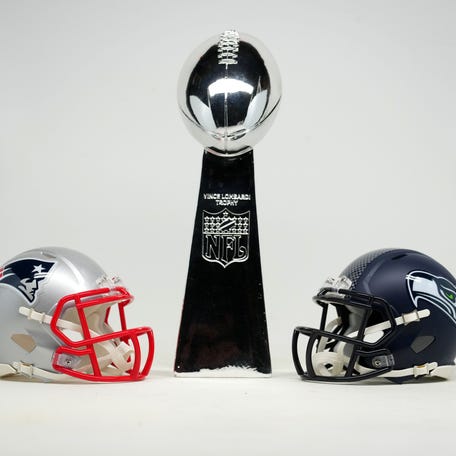 Jan 29, 2026; Santa Clara, California, USA; New England Patriots and Seattle Seahawks helmets with Super Bowl Vince Lombardi trophy.