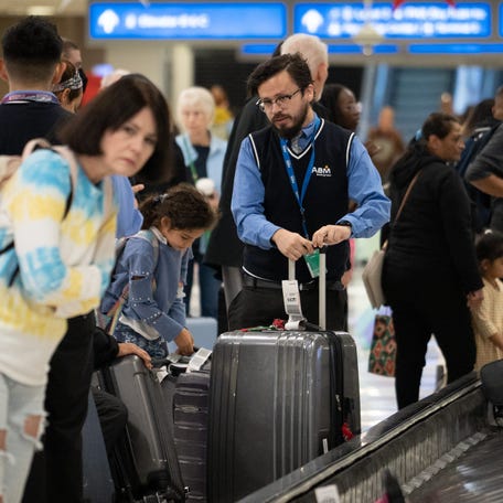 Travelers wait for their luggage in Terminal 4 on Nov. 22, 2023, at Sky Harbor International Airport in Phoenix.