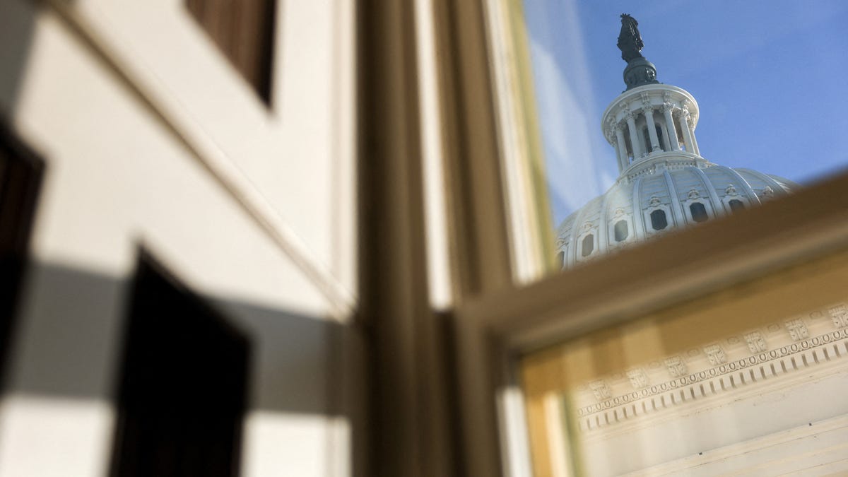 The dome of the U.S. Capitol is framed through a window, as members of Congress work to resolve a dispute over immigration enforcement on Capitol Hill on January 30, 2026.