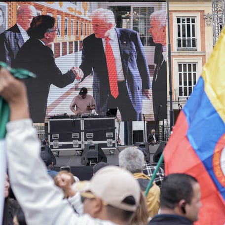 A screen shows Colombian President Gustavo Petro and U.S. President Donald Trump shaking hands, as people attend a rally, called by the Colombian government, in support of Petro during his ongoing visit to the U.S., at Plaza Bolivar in Bogota, Colombia, February 3, 2026. REUTERS/Nathalia Angarita
