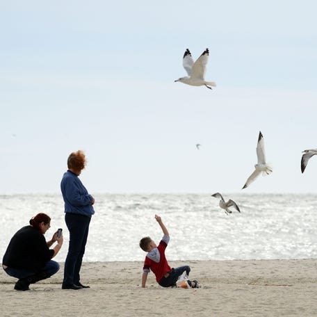 From left, Gretchen Rundecker, Pat Rundecker and Caiden Rundecker of Haskell, New Jersey, feed seagulls in Cape May, New Jersey in this file photo from Oct. 27, 2012.