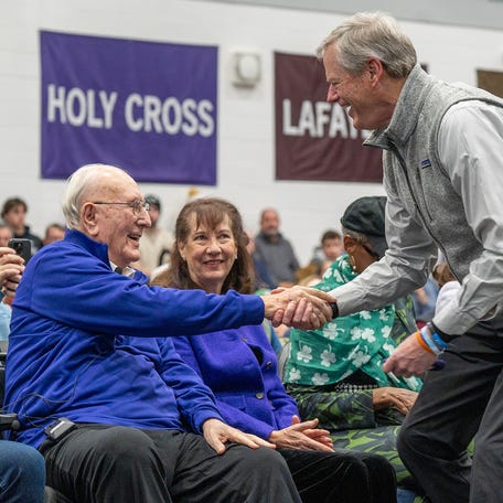 NCAA president Charlie Baker, former governor of Massachusetts, greets Bob Cousy during a program at College of the Holy Cross Feb. 7.