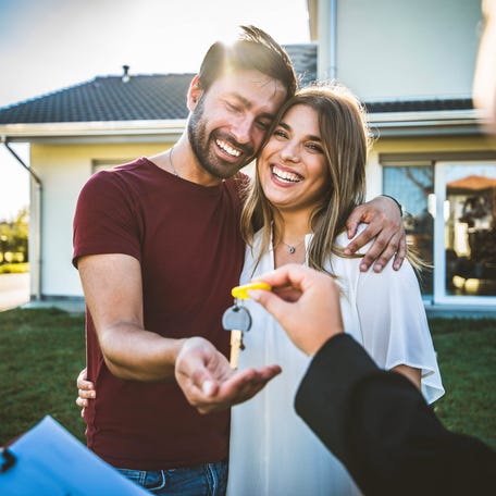 Couple receives keys from their real estate agent.