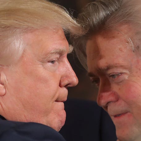U.S. President Donald Trump talks to senior staff Steve Bannon during a swearing in ceremony for senior staff at the White House in Washington, DC January 22, 2017.
