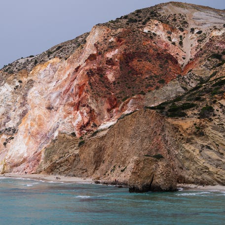 The beach at Firiplaka, almost deserted in spring, is dominated by mineral cliffs in shades of yellow and ochre in Greece Cyclades islands, on Milos, May 7, 2025.