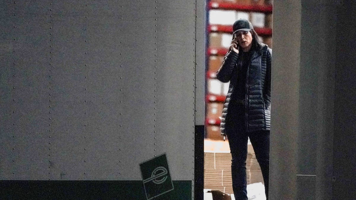 United States Director of National Intelligence Tulsi Gabbard speaks on the phone while standing at the edge of a truck loading bay after the Federal Bureau of Investigation (FBI) executed a search warrant for the Fulton County Election Hub and Operation Center in relation to the 2020 election, according to a law enforcement official familiar with the matter, in Union City, Georgia, U.S. January 28, 2026.