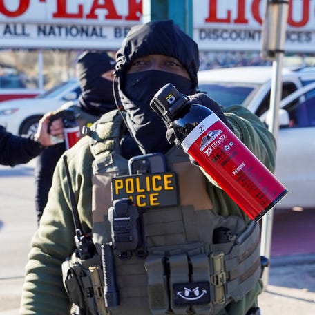 A federal agent points pepper spray at the press as they conduct an immigration raid days after a U.S. Immigration and Customs Enforcement (ICE) agent fatally shot Renee Nicole Good, in Minneapolis, Jan. 14, 2026.