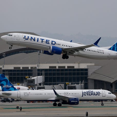 A United Airlines plane takes off from Los Angeles International Airport over a taxiing Jet Blue Airlines plane on May 29, 2025 in Los Angeles, California.