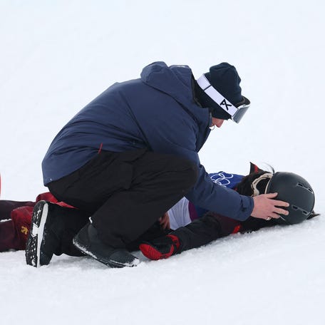Jiayu Liu of China receives medical attention after falling during her run in the women's snowboard halfpipe qualification at Livigno Snow Park in Livigno, Italy on Feb. 11, 2026.
