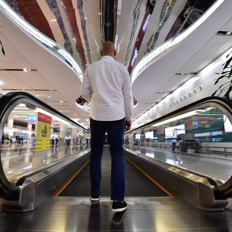 A traveler steps onto a moving walkway at Dubai International Airport's Terminal 3 in this file photo from Oct 2018.