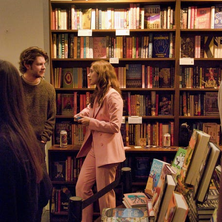 A Bored of Dating Apps host gives the rundown to a participant at a Valentine's Day meet-cute event.