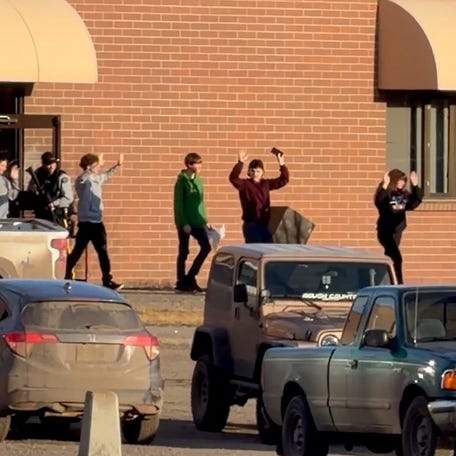 Students walk out of the school building with their hands up after an assailant opened fire at a high school in the town of Tumbler Ridge, British Columbia, Canada, on Feb. 10, 2026.