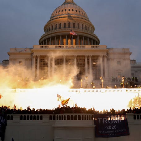 An explosion caused by a police munition is seen while supporters of President Donald Trump riot in front of the U.S. Capitol in Washington, DC, on Jan. 6, 2021.