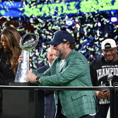 Seattle Seahawks' quarterback #14 Sam Darnold (R) watches as General Manager John Schneider grabs the Vince Lombardi Trophy after the Seahawks defeated the New England Patriots during Super Bowl LX at Levi's Stadium in Santa Clara, California on February 8, 2026.