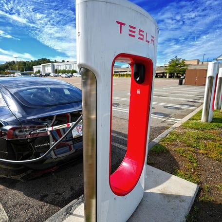 A Tesla charges at the EV charging station at the Auburn Mall.