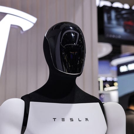 A Tesla Optimus robot is displayed next to a logo at the company’s booth at the 8th China International Import Expo (CIIE) in Shanghai, China, November 6, 2025.REUTERS/Maxim Shemetov