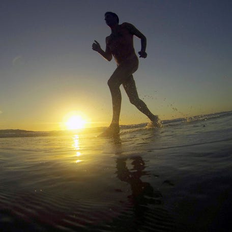 Francois, a 48-year-old French naturist, jogs on the beach at sunset during his holidays at the Centre Helio-Marin (Center for Sun and Sea) naturist campsite on the Atlantic coast in Montalivet, southwestern France, on Aug. 12, 2013.