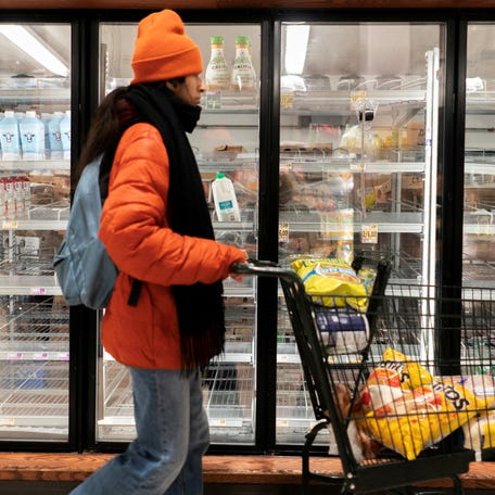 FILE PHOTO: A shopper walks past a partially empty dairy section at a grocery store in Washington, D.C., U.S., January 24, 2026. REUTERS/Nathan Howard/File Photo