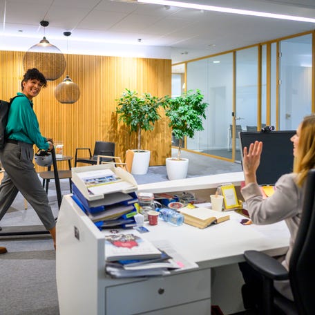Worker entering in office with push scooter.