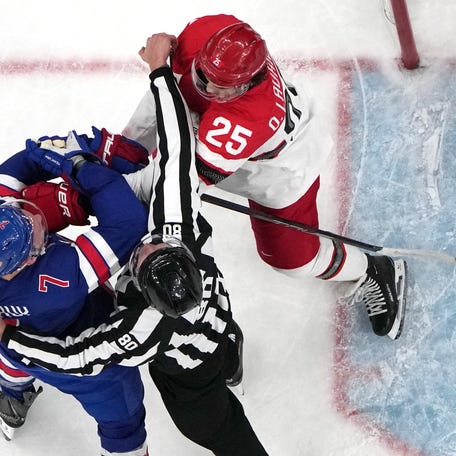 Brady Tkachuk of United States clashes with Oliver Lauridsen of Denmark in men's ice hockey group C play during the Milano Cortina 2026 Olympic Winter Games at Milano Santagiulia Ice Hockey Arena.