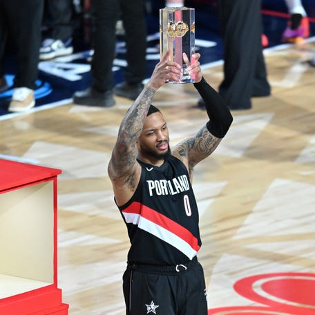 Portland Trail Blazers guard Damian Lillard (0) celebrates with the trophy after winning the 3-point contest.