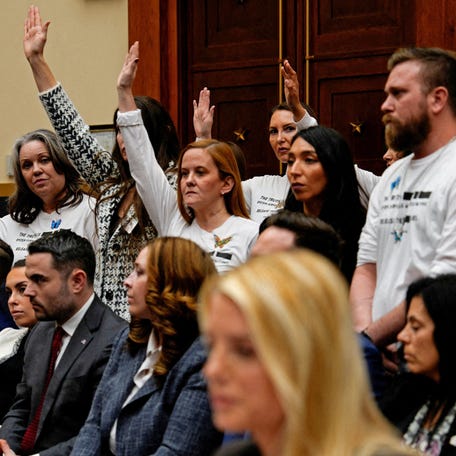 Survivors of Jeffrey Epstein raise their hands after Rep. Dan Goldman (D-NY) asked who of them has been unable to meet with the U.S. Department of Justice, as during a House Judiciary Committee hearing on oversight of the Justice Department, on Capitol Hill in Washington, D.C., U.S., February 11, 2026.