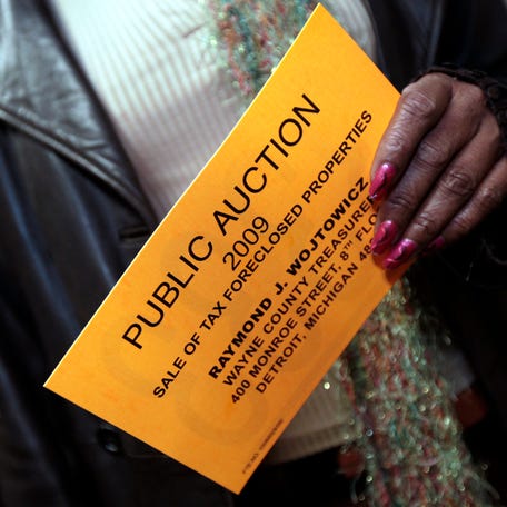 A registered bidder holds her bidders card before the start of the Wayne County tax foreclosures auction of nearly 9,000 properties in Detroit, Michigan October 19, 2009.