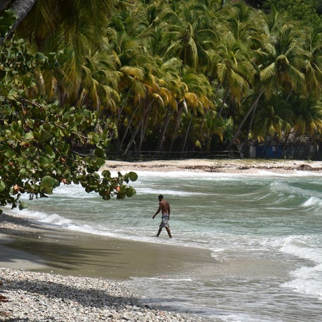 A man walks on a beach close to the the city of Jacmel, 95 km (about 60 miles) south-west of Port-au-Prince, on September 26, 2018. (Photo by HECTOR RETAMAL / AFP) (Photo credit should read HECTOR RETAMAL/AFP via Getty Images)