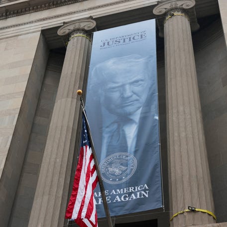 New banners depicting President Donald Trump are hung on the Department of Justice in Washington, DC, on Feb. 19, 2026.