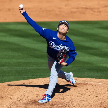Los Angeles Dodgers pitcher Yoshinobu Yamamoto throws against the Los Angeles Angels during a spring training game at Tempe Diablo Stadium.