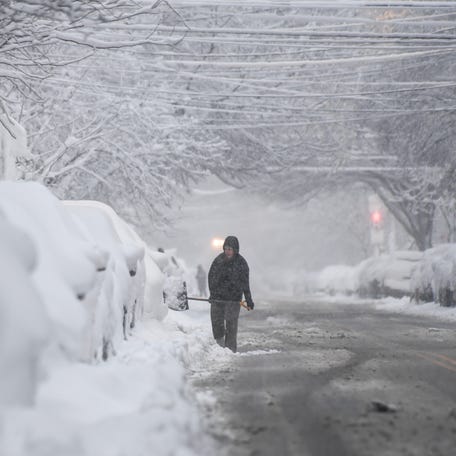 Residents in Philadelphia dig out their cars as heavy snow continues to fall on Feb. 23, 2026.