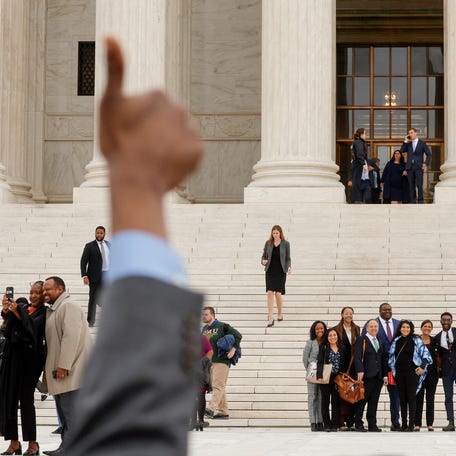A supporter gives a thumbs-up to lawyers arguing on behalf of affirmative action as they depart after the Supreme Court heard appeals in two cases on the legality of race-conscious admissions policies on October 31, 2022.