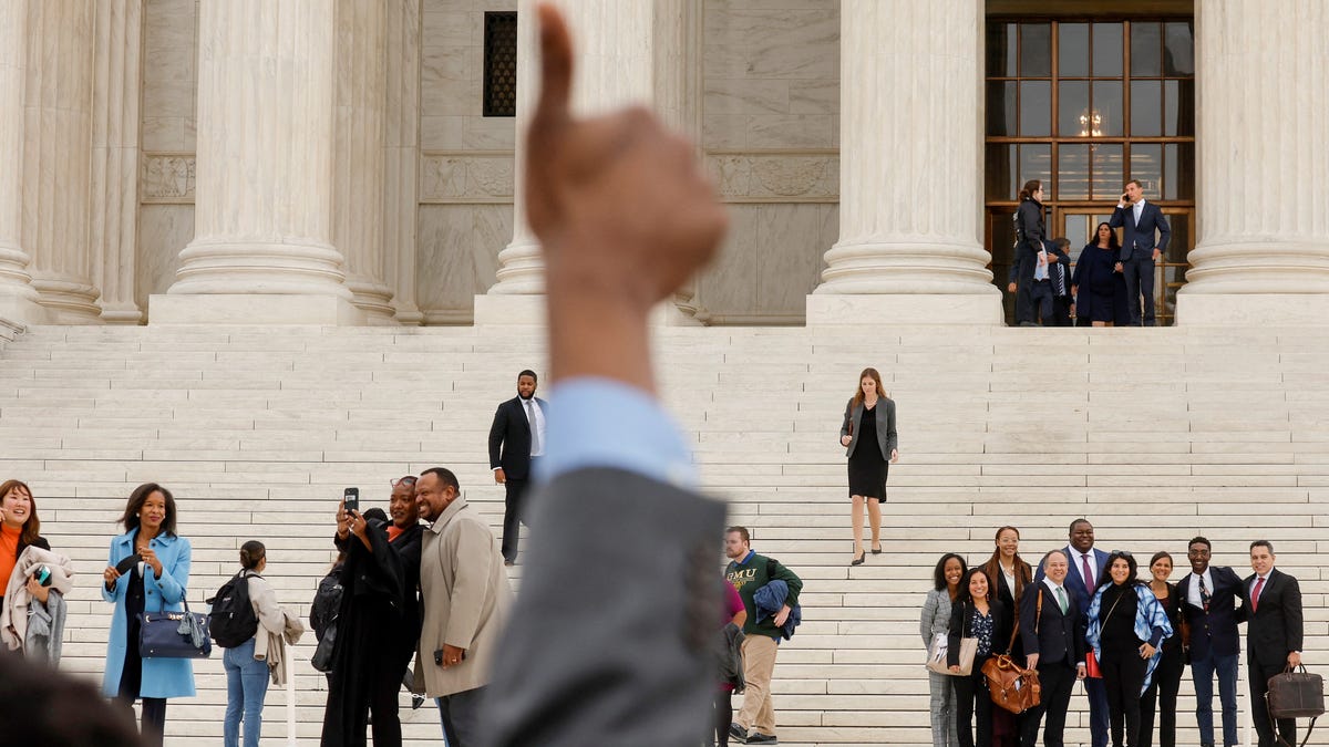 A supporter gives a thumbs-up to lawyers arguing on behalf of affirmative action as they depart after the Supreme Court heard appeals in two cases on the legality of race-conscious admissions policies on October 31, 2022.
