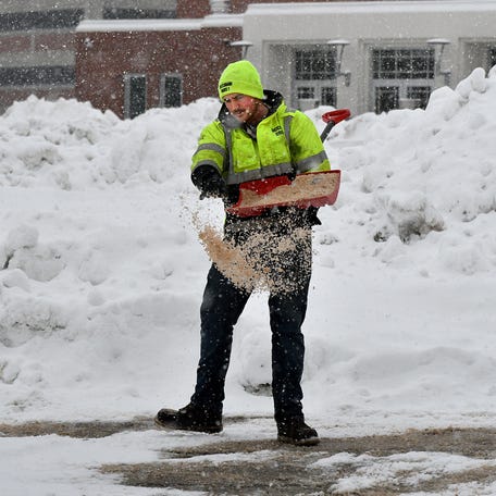 During another round of snow, albeit much smaller than Monday's blizzard, Ricciardi Bros. of West Boylston employee Kyle Norrman spreads salt on sidewalks at Worcester State University on Wednesday, Feb.25.