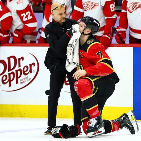 A towel is held to the face of Ottawa Senators left wing Brady Tkachuk (7) after a hit to the face during the second period against the Detroit Red Wings.