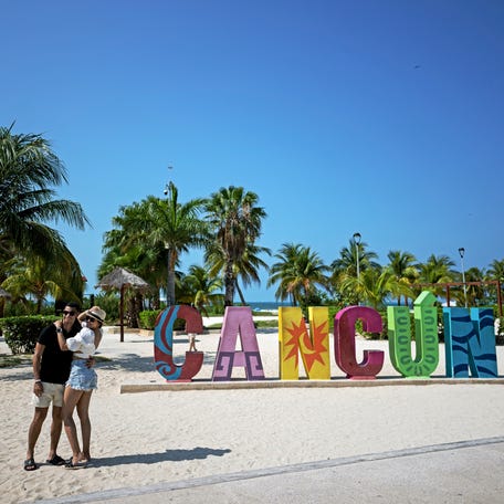 A couple takes a selfie at a beach in Cancun, Mexico, on April 23, 2024.
