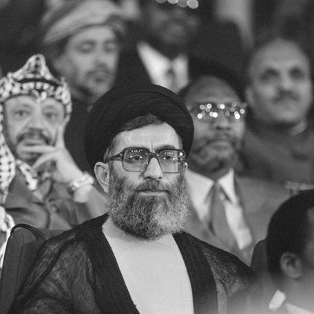 Iranian President Ali Khamenei listens to a speech during the Non-Aligned Movement summit as PLO leader Yasser Arafat sits in the background, in Harare, Zimbabwe. September 1, 1986.