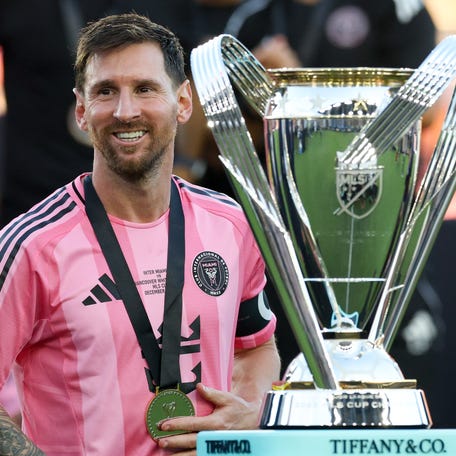 Dec 6, 2025; Fort Lauderdale, Florida, USA; Inter Miami forward Lionel Messi (10) looks on with the Philip F. Anschutz trophy after winning the 2025 MLS Cup against the Vancouver Whitecaps FC at Chase Stadium. Mandatory Credit: Nathan Ray Seebeck-Imagn Images