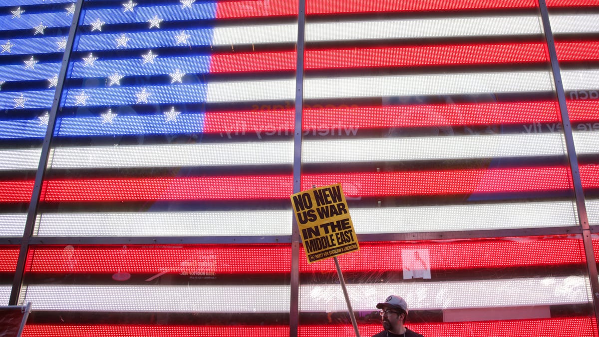 A person holds a sign during a Stop the War on Iran protest at Times Square in New York City on February 28, 2026. The US and Israel launched an attack of unprecedented scale against Iran on Saturday, reportedly killing more than 200 people, with Tehran launching a retaliatory missile barrage that sent people running for cover across the Middle East.