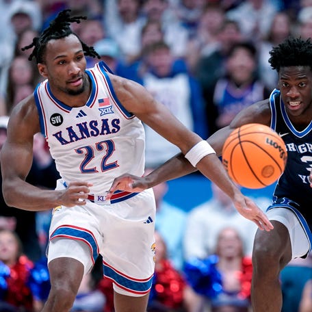 Darryn Peterson #22 of the Kansas Jayhawks and forward AJ Dybantsa #3 of the BYU Cougars chase down a loose ball in the first half at Allen Fieldhouse on January 31, 2026 in Lawrence, Kansas.