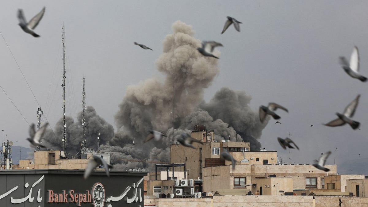 Birds fly as smoke rises from an air strike explosion in Tehran, Iran, on March 2, 2026.