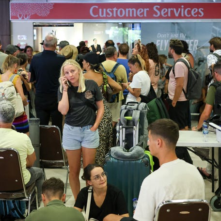 Stranded passengers wait near Emirates Airways customer service office at I Gusti Ngurah Rai International Airport after flights to Doha, Dubai, and Abu Dhabi were cancelled following strikes on Iran launched by the United States and Israel.