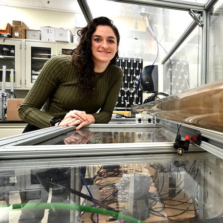 WPI student Amelia Kokernak with the Deflagration-to-Detonation Transition (DDT) experiment.